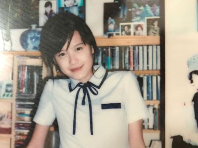 Koo Hye-Sun is in her school uniform as she poses in front of a bookshelf.